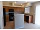 Kitchen with wooden cabinets, black appliances, tile floor, and granite countertops at 319 Mulberry Glen Dr, North Las Vegas, NV 89031