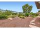 Spacious backyard featuring desert landscaping, stone accents, and a wrought iron fence at 3805 Specula Wing Dr, North Las Vegas, NV 89084