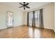 Bright bedroom with wood-look floors, modern ceiling fan, and a glass panel door leading to the outside at 3805 Specula Wing Dr, North Las Vegas, NV 89084