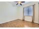 This bedroom features a ceiling fan, wood-style tile flooring, and a window with blinds and curtains at 3805 Specula Wing Dr, North Las Vegas, NV 89084