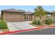 Charming single-story home with a two-car garage, desert landscaping, and a red concrete curb at 3805 Specula Wing Dr, North Las Vegas, NV 89084