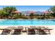 Relaxing pool with lounge chairs, umbrellas, and mountain views provide a resort-style experience at 3805 Specula Wing Dr, North Las Vegas, NV 89084