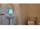 A cozy half-bathroom features a pedestal sink, toilet and decorative mirror at 386 Botanic Gardens Dr, Las Vegas, NV 89148