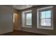 Bright bedroom featuring wood floors, two windows, and neutral walls at 386 Botanic Gardens Dr, Las Vegas, NV 89148
