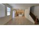 Bright open-concept living space with tile flooring that flows into the adjacent kitchen and staircase at 386 Botanic Gardens Dr, Las Vegas, NV 89148
