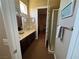 Well-lit bathroom with double sinks, dark wood cabinetry, and an open doorway to a shower at 4208 Agosta Luna Pl, Las Vegas, NV 89135