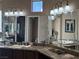 Bathroom vanity with granite counters, etched mirrors, and ample lighting, offering a luxurious feel at 4208 Agosta Luna Pl, Las Vegas, NV 89135