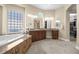 Bright bathroom with walk in closet, granite counters, and tiled bathtub with decorative window at 4208 Agosta Luna Pl, Las Vegas, NV 89135