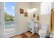 Bright bathroom with backyard pool view, complemented by a single sink vanity and modern toilet at 4208 Agosta Luna Pl, Las Vegas, NV 89135