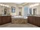 Bathroom featuring stone bathtub, dual vanity sinks and natural lighting at 4208 Agosta Luna Pl, Las Vegas, NV 89135