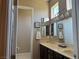 Bright bathroom with double sinks, decorative mirrors, and dark cabinets at 4208 Agosta Luna Pl, Las Vegas, NV 89135