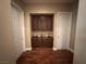 Hallway featuring dark wood floors, neutral walls, and a built-in cabinet for storage and decor at 4208 Agosta Luna Pl, Las Vegas, NV 89135