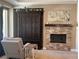 Living room featuring a fireplace with decorative stonework, armchair, and large cabinet at 4208 Agosta Luna Pl, Las Vegas, NV 89135