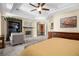 Spacious main bedroom featuring a fireplace, built-in entertainment center, and sitting area at 4208 Agosta Luna Pl, Las Vegas, NV 89135