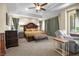 Relaxing main bedroom featuring tray ceilings, ceiling fan, and comfortable seating at 4208 Agosta Luna Pl, Las Vegas, NV 89135