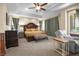 Spacious main bedroom featuring tray ceilings, ceiling fan, and sitting area at 4208 Agosta Luna Pl, Las Vegas, NV 89135