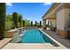 Sparkling pool features a waterfall, manicured landscaping, and covered patio for comfortable outdoor living and entertaining at 4208 Agosta Luna Pl, Las Vegas, NV 89135