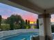Backyard swimming pool featuring colorful sunset views, outdoor living area, and lush greenery at 4208 Agosta Luna Pl, Las Vegas, NV 89135