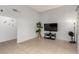 Bright living room with neutral walls, tiled floors, entertainment center and large tv at 4213 Essex Green Ct, Las Vegas, NV 89110