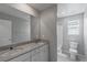 Bathroom featuring double sinks, gray quartz countertop, white cabinets and large mirror at 4589 Swimming Minnow Ave, Las Vegas, NV 89141
