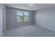 The empty bedroom has neutral carpet, two sunny windows, and ample space to make it your own at 4589 Swimming Minnow Ave, Las Vegas, NV 89141