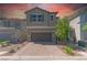 Two-story home with a two-car garage, charming stone accents, and desert landscaping at 4589 Swimming Minnow Ave, Las Vegas, NV 89141