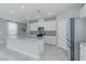 Modern kitchen with stainless steel appliances, island with seating, and tile backsplash at 4589 Swimming Minnow Ave, Las Vegas, NV 89141