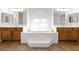 Luxurious bathroom with a soaking tub, dual sinks, and plenty of natural light at 5120 Mirage Garden St, Las Vegas, NV 89130
