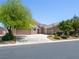 Front exterior of the home featuring mature landscaping, three-car garage, and modern design at 5120 Mirage Garden St, Las Vegas, NV 89130