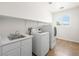 Well-lit laundry room with modern washer and dryer, plus sink and storage space at 5120 Mirage Garden St, Las Vegas, NV 89130