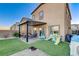 Backyard view, showcasing the patio, artificial turf, and playset at 5236 Sunstone Mesa Dr, Las Vegas, NV 89166