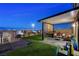 Serene backyard with covered patio, lush grass, and seating area, perfect for outdoor relaxation at 5236 Sunstone Mesa Dr, Las Vegas, NV 89166