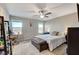 Bright bedroom featuring a modern ceiling fan, picturesque windows, and a cozy sitting area with mountain views at 5236 Sunstone Mesa Dr, Las Vegas, NV 89166