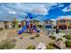 Community playground with a blue and red play structure, benches, and mature landscaping in a residential area at 5236 Sunstone Mesa Dr, Las Vegas, NV 89166