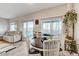 Dining area with a dark wood table, white chairs, sliding glass doors to the patio, and views of the backyard at 5236 Sunstone Mesa Dr, Las Vegas, NV 89166