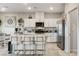 Bright kitchen with white cabinets, stainless steel appliances, granite countertops, and seating at the large central island at 5236 Sunstone Mesa Dr, Las Vegas, NV 89166