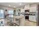 Modern kitchen featuring a granite island with bar seating, stainless steel appliances, and an adjacent outdoor patio at 5236 Sunstone Mesa Dr, Las Vegas, NV 89166