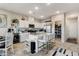 Open concept kitchen featuring white cabinets, granite countertops, stainless appliances, and a central island with bar seating at 5236 Sunstone Mesa Dr, Las Vegas, NV 89166