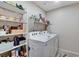 Convenient laundry room with modern washer and dryer units, shelving, and ample storage space at 5236 Sunstone Mesa Dr, Las Vegas, NV 89166