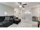 Spacious living area featuring neutral walls, plush gray carpeting, and a comfortable sectional with stylish patterned pillows at 5236 Sunstone Mesa Dr, Las Vegas, NV 89166