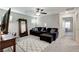 Inviting living room features a modern ceiling fan, plush gray carpet, and a comfortable, dark-colored sectional sofa at 5236 Sunstone Mesa Dr, Las Vegas, NV 89166