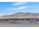 Panoramic view of the mountain range and community rooftops, complete with solar panels, under a clear blue sky at 5236 Sunstone Mesa Dr, Las Vegas, NV 89166