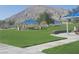Shaded picnic area features covered tables and lush green lawn with mountain views at 5236 Sunstone Mesa Dr, Las Vegas, NV 89166