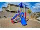 A colorful, modern play structure is set against a decorative brick wall in a pleasant neighborhood setting at 5236 Sunstone Mesa Dr, Las Vegas, NV 89166