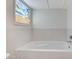 Bathtub with decorative stained glass window and white tile at 532 Greenbriar Pl, Boulder City, NV 89005