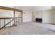 Open living room with neutral carpet, black fireplace and staircase with wooden beams at 532 Greenbriar Pl, Boulder City, NV 89005