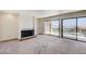 Open living room with fireplace, large glass doors to the exterior and neutral carpet at 532 Greenbriar Pl, Boulder City, NV 89005