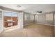 Open concept living room with neutral paint, tile floors, a ceiling fan and sliding glass doors to the patio at 5695 Merced St, Las Vegas, NV 89148