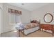 Cozy bedroom with a floral bedspread, wood floors, and round mirror at 6039 Tokara Ave, Las Vegas, NV 89122