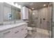 Modern bathroom featuring gray tiling, glass shower doors, and marble countertops at 616 Fernbrook Dr, Henderson, NV 89002